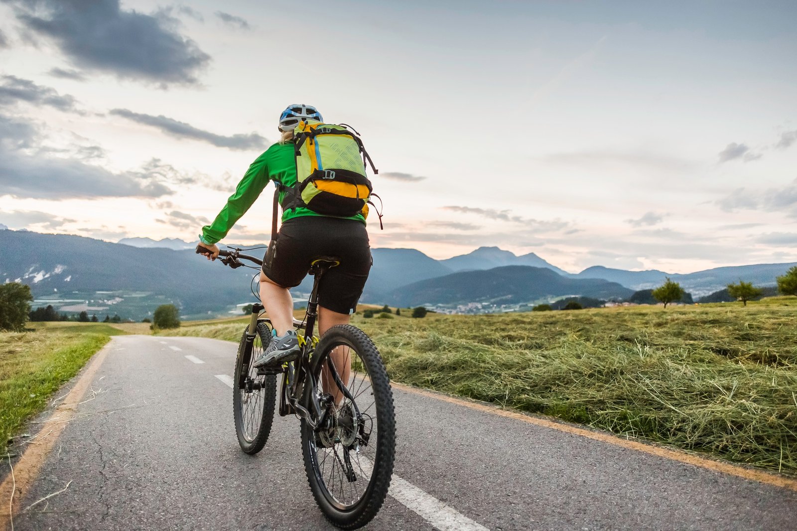 Woman cycling on road, Fondo, Trentino, Italy